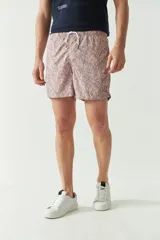 Short de baño estampado con diseño geométrico en tonos verdes, cintura elástica con cordón ajustable, bolsillos laterales y bolsillo trasero.