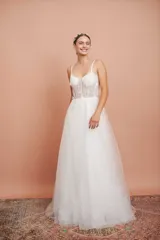 Vestido largo de microtul blanco con brillo y apliques de flores, con breteles finos y falda con vuelo. Ideal para quinceañeras.