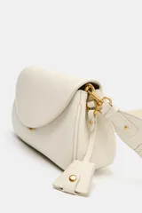Bolso bandolera alargado de color blanco marfil con solapa redondeada y detalle metálico dorado. Incluye doble asa bandolera ajustable, una de ellas en tejido.