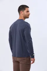 Remera de algodón de manga larga color azul marino, con cuello redondo y estampado frontal en tonos celestes y dorados que dice "Celebrating All Good Things Legacy Brand Since 1972" y "Live a life that you would relive".