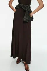 Vestido largo de corte evasé, con cuello subido y diseño sin mangas. Presenta cierre en la espalda con botones y una caída fluida.