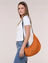 Cartera bandolera de lona naranja en forma de medialuna, con correa ajustable negra y cierre principal.
