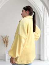 Camperón de mujer color crema, estilo teddy, con cierre frontal y bolsillos laterales.