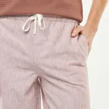 Pantalón de mezcla de lino color rosado claro con rayas verticales finas, corte recto y cintura elástica con cordón ajustable.