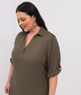 Vestido corto tipo chemise de Ashua, color verde militar, con escote en V, cuello camisero, mangas 3/4 y bolsillos laterales.