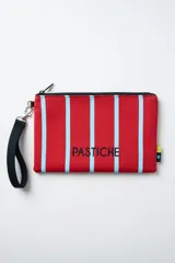 Neceser tipo pouch de neopreno con estampa de rayas rojas y celestes, cierre superior y correa de mano negra extraíble.