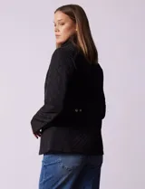 Campera capitoneada marca Gallery, color negro, con cierre frontal, cuello alto y bolsillos laterales con cierre. Presenta un diseño acolchado con costuras en rombos y ajuste en la cintura.