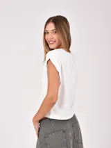 Remera blanca de manga corta y cuello redondo, con diseño holgado y hombros ligeramente caídos.