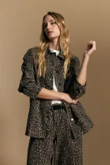 Sobrecamisa de silueta relajada con estampado animal print, cuello camisero, cierre frontal con botones y bolsillos aplicados.