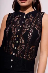 Blusa negra sin mangas de encaje con botones frontales.