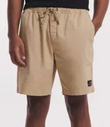 Bermuda masculina de sarga color blanco, con cintura elástica y lazo de ajuste. Presenta bolsillos laterales y una etiqueta decorativa aplicada en la parte inferior de la pierna.