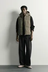 Chaleco acolchado puffer color negro para hombre, de corte regular fit, con capucha ajustable, cierre frontal de cremallera y bolsillos laterales de vivo.