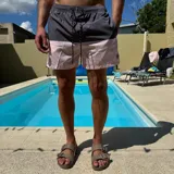 Short de baño negro con cintura elástica y cordón ajustable bicolor. Presenta un parche circular con logo en la parte inferior de la pierna.