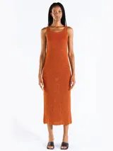 Vestido midi sin mangas confeccionado en punto jersey de tejido italiano con hilo Lurex en dos colores que aporta brillo sutil. Presenta escote bote redondeado y aberturas laterales.