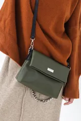 Cartera de hombro color beige, con solapa frontal y correa ajustable combinada en cuero liso negro y cadena metálica plateada.