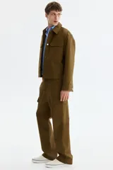 Pantalón cargo de algodón en color verde militar con corte relajado, bolsillos al bies en los laterales, bolsillos de parche con solapa en las piernas y cierre frontal con botón a presión.