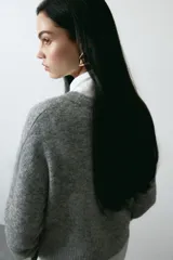 Buzo de punto gris melange con diseño jacquard y la palabra 'ADORE' en blanco en el frente, cuello redondo y hombros caídos.