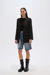 Blazer negro de corte holgado con cuello solapa y bolsillos frontales.