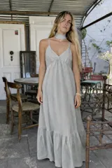 Vestido largo negro de algodón con breteles finos, escote en V y choker al cuello. Falda amplia con volado en el ruedo.