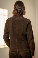 Blazer de gamuza color chocolate, con cuello camisero, cierre frontal de botones nacarados y corte entallado.