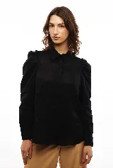 Camisa blanca de lino con cuello clásico, mangas largas con volumen y frunces en los hombros.