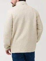 Buzo de hombre con diseño acolchado de rombos, cuello alto con cierre de broches y manga larga. Presenta un parche decorativo en el pecho y bolsillos frontales.