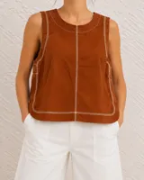 Musculosa de color marrón tostado con cuello redondo, diseño sin mangas y costuras visibles en color blanco contrastante.