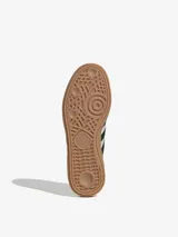 Championes Adidas Handball Spezial color crema con las tres tiras laterales en negro y suela de goma marrón.