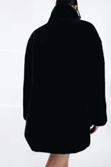 Abrigo de Zara con efecto pelo, cuello de solapa con muescas, manga larga y bolsillos delanteros. Cuenta con forro interior a tono y cierre frontal mediante ganchos metálicos.