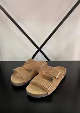 Sandalias planas color beige, con dos tiras anchas ajustables con hebilla y suela de corcho.