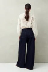 Jean de tiro alto, color negro lavado, con calce ultra wide leg y silueta amplia desde la cadera hasta el bajo.