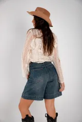 Bermuda de jean azul claro, corte a la rodilla, con bolsillos delanteros y traseros.