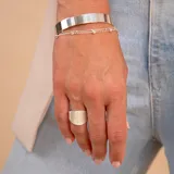 Brazalete tipo esclava de diseño minimalista y superficie lisa, confeccionado en plata 925. Presenta una estructura rígida y abierta, ideal para uso diario.