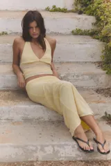 Falda midi de tiro medio, confeccionada en tejido semitransparente color amarillo con estampado de lunares diminutos en tono rosado. Cuenta con cintura elástica y forro interior a tono.