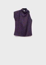 Blusa sin mangas de corte recto con cuello drapeado y cierre de botones. Presenta un diseño estampado de lunares en color azul sobre fondo oscuro.