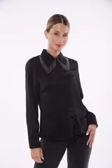 Camisa negra de manga larga con cuello clásico y detalle de flecos metálicos en el cuello.