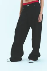 Jean de corte oversize y tiro medio-bajo, confeccionado en algodón, con diseño de cinco bolsillos y cierre frontal con botón metálico.