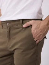 Pantalon cargo de gabardina color negro, con corte regular fit, tiro medio, cierre de boton y cremallera, y bolsillos laterales tipo cargo.