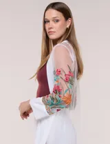 Cardigan tipo kimono largo de tul blanco semitransparente, con frente abierto y mangas largas. Presenta vistosos bordados florales multicolor en mangas, dobladillo y laterales.