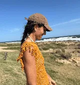 Musculosa tejida en punto calado, color violeta, con diseño sin mangas y detalle de flecos en los hombros.