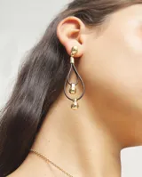 Pendientes colgantes de diseño geométrico, compuestos por una estructura de cuero negro en forma de gota doble y detalles de esferas irregulares en aleación de metales con baño de oro 18k.