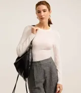 Suéter de punto color blanco, con cuello redondo, manga larga y textura geométrica de losângos.
