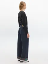 Jean de pierna ancha de denim raw, tiro medio-alto y dobladillo en bajos.