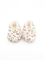Pantuflas tipo botita de peluche, con estampado animal print en tonos marrones sobre fondo blanco. Interior forrado en material suave y cálido.