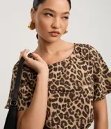 Enterito corto de mangas cortas con estampado de leopardo. Presenta cuello redondo con cierre tipo gota en la espalda, elástico en la cintura y lazo ajustable a juego.