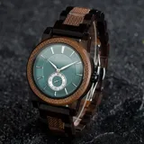 Reloj de pulsera Chenaut modelo Émeraude d’Ébène, con caja y malla de madera de ébano y nogal. Esfera verde esmeralda con segundero pequeño. Cristal Hardlex y movimiento de cuarzo. Resistente al agua (3 ATM).