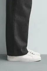Zapatilla de estilo minimalista con cordones, confeccionada en material sintético de acabado mate. Presenta una horma redonda, forro interior en tono contrastante y suela de goma con textura ligera.