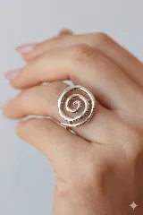 Anillo abierto ajustable con diseño de espiral orgánica en acabado dorado.