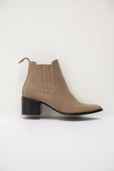 Bota de cuero color chocolate con diseño versátil que incluye una polaina desmontable. Presenta punta fina, taco cuadrado y un detalle bordado en la parte superior de la caña.