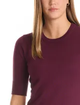 Buzo de tejido fino en color azul marino, con cuello redondo y mangas cortas con puños acanalados.